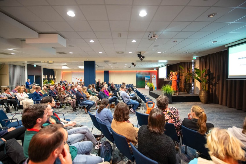 Deelnemers studiedag luisteren naar presentatie