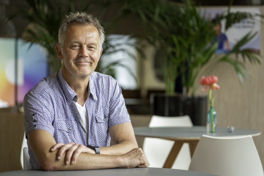 Henri van der Velden, zittend aan tafeltje met handen op tafel