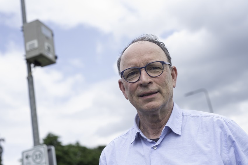 Stuurgroeplid Theo Geldens bij meetbox meetnet op achtergrond