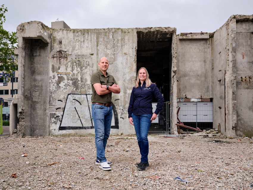 Hanneke Dekker, medewerker handhaving asbest (ODZOB), en Jordi de Ruijter, vergunningverlener asbest (ODZOB) samen op foto bij een gebouw dat gesloopt wordt