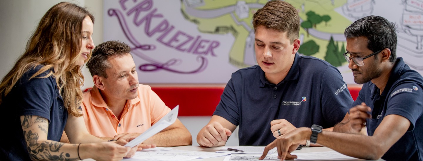 Toezichthouders Youri en Amrit in overleg met 2 collega's op kantoor ODZOB