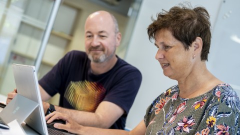 Kantoorfoto met 2 medewerkers achter laptop 