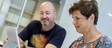 Kantoorfoto met 2 medewerkers achter laptop 